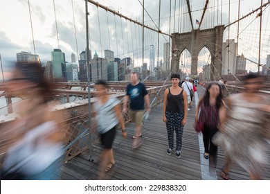 Young Woman On Brooklyn Bridge With Blurred People Passing Around