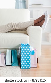 Young Woman On Couch Putting Her Feet Up