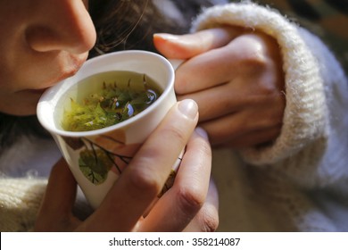 A young woman on the couch and with sage tea on the hand. - Powered by Shutterstock
