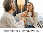 Young woman on a cozy couch signs with her therapist, showing empathy and connection in mental health counseling. The therapist listens attentively, creating a safe space. Sign language concept