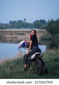 A Young Woman On A Cross - Country Motorcycle Or Pit Bike At Sunset . Active Recreation