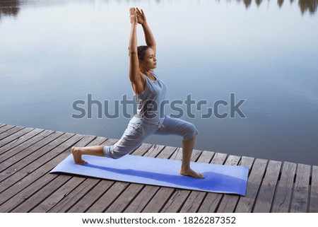 Similar – Active slim young woman doing yoga by the lake