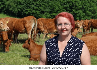 Young woman on farm with brown cows