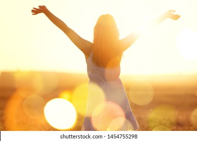 Young Woman On Field Under Sunset Light