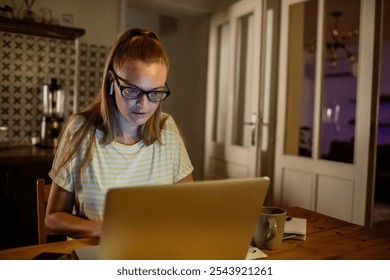 Young woman on a late night video call working remotely from home - Powered by Shutterstock