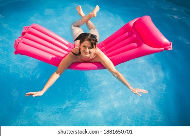 Young Woman On Pool Air Mattress In Above Ground Pool. Lifestyle At Home Concept.