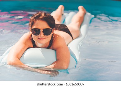 Young Woman On Pool Air Mattress In Above Ground Pool. Lifestyle At Home Concept.