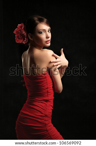 Young woman on red dress, isolated on black background