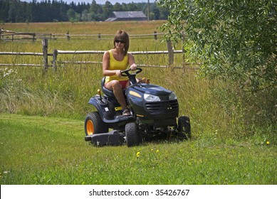 The Young Woman On Riding Lawn Mower