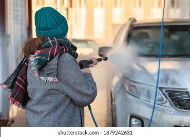 Young Woman Is On Self-service Car Wash, Rear View, Winter Season