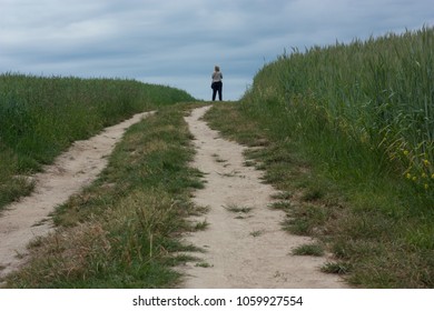 Young woman on a stormy sky background on a field road. - Powered by Shutterstock