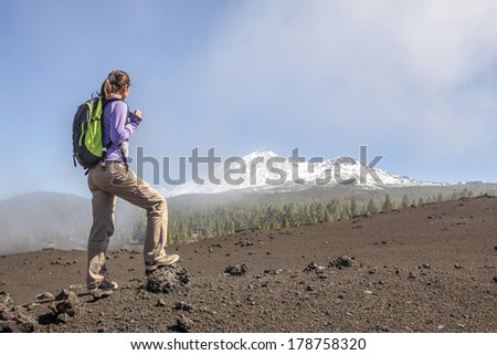 young woman on top of a mountain enjoying the view of volcano teide in tenerife
