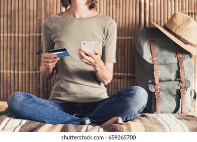 Young Woman On Vacations Using Smartphone And Credit Card. Online Shopping And Travel Concept