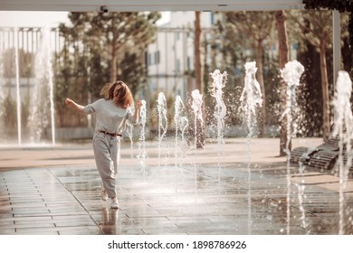 Young Woman On A Walk In The City By The Fountains