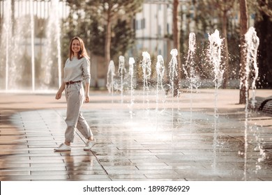 Young Woman On A Walk In The City By The Fountains