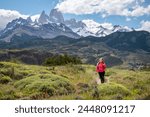 Young woman on the way to Fitz Roy, El Cahlten, Argentina. Mountaineer venturing to Fitz Roy Mountain. Happy tourist in Argentine Patagonia with Fitz Roy in the background