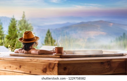 Young woman in an open air bath with view of the mountains. - Shutterstock ID 1229758582