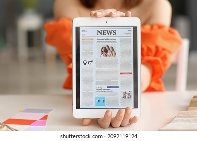 Young Woman With Open Page Of Online Newspaper At Home