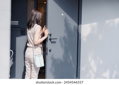 Young woman opening the front door of a house - Powered by Shutterstock