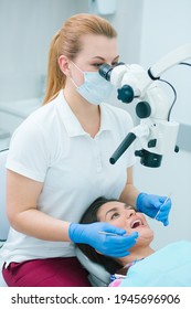 Young Woman Opening Her Mouth Under The Dental Microscope While A Doctor Looking At Her Teeth