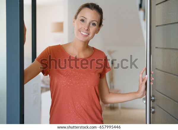 Young Woman Opening House Front Door Stock Photo (Edit Now) 657995446