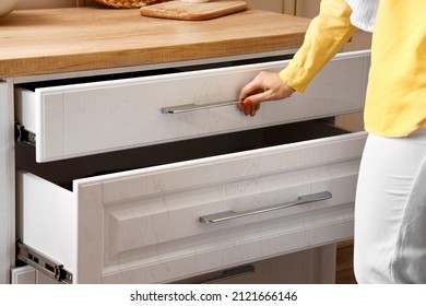 Young Woman Opening Kitchen Drawer, Closeup