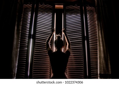 Young Woman Opening Shutters