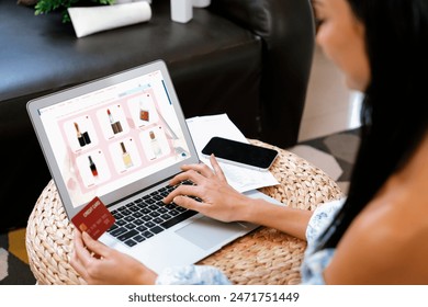 Young woman order or purchase product on internet using laptop and make transaction payment by smartphone. Online shopping lifestyle with credit card via internet banking on mobile application. Blithe - Powered by Shutterstock