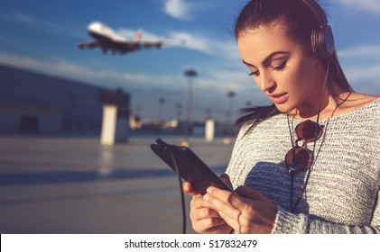 Young Woman Ordering Air Ticket By Tablet On Airport