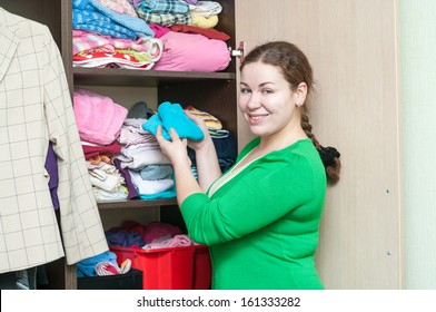 Young Woman Organizing Clothes In The Wardrobe Closet At Home