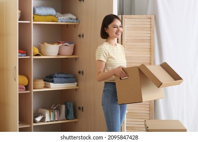 Young Woman Organizing Clothes At Wardrobe