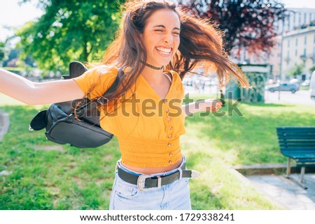 young woman outdoor having fun laughing spreading arms - getting away from it all, spontaneous, positive emotions concept