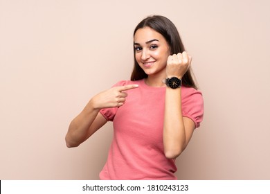 Young Woman Over Isolated Background Showing The Hand Watch