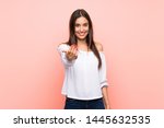 Young woman over isolated pink background inviting to come with hand. Happy that you came