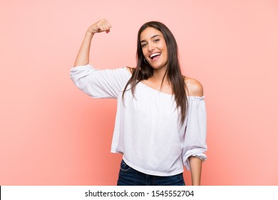 Young woman over isolated pink background doing strong gesture