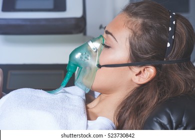 young woman with oxygen mask at hospital or cosmetics salon