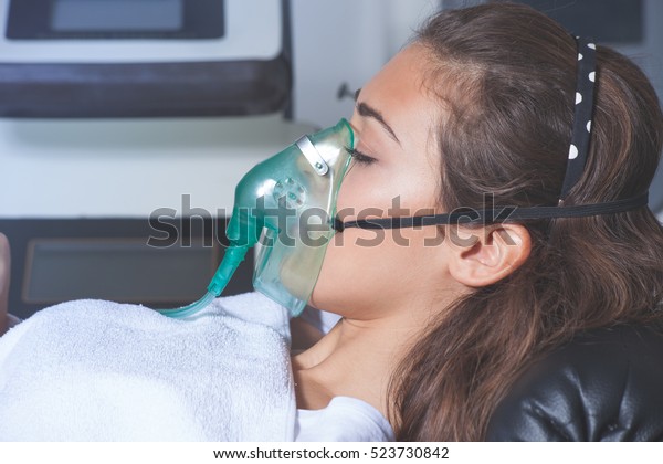 young woman with oxygen mask at hospital or\
cosmetics salon\
