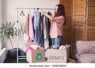 Young Woman packing clothes into donation box in living room at home. Volunteer girl holds a donate box of things for people in need and box for recycle - Shutterstock ID 2208784025