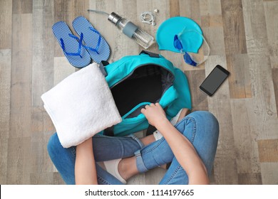 Young Woman Packing Sports Bag On Floor, Top View