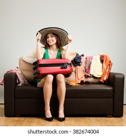 Young Woman Packing A Travel Bag On The Plane Before Going On Holiday. Gray Background, Easy To Remove.