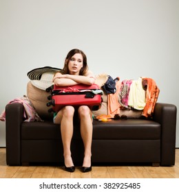 Young Woman Packing A Travel Bag On The Plane Before Going On Holiday. Gray Background, Easy To Remove.