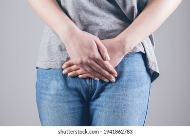 Young Woman With Painful Abdominal Pain With Hands Holding Pressing Down On Her Crotch In The Lower Abdomen.