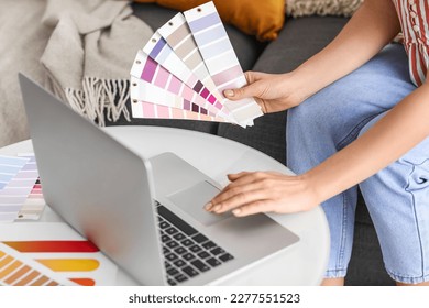 Young woman with paint color palettes using laptop at home, closeup - Shutterstock ID 2277551523