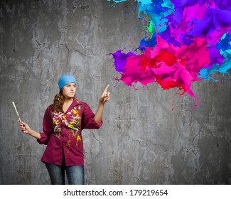 Young Woman Painter Coloring Wall With Brush