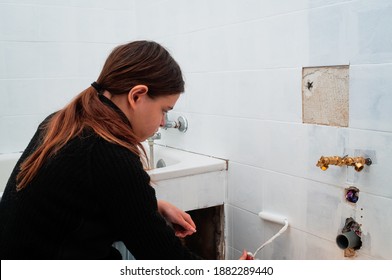young woman painting bathroom ceramic  wall tiles ,do it your self ,renovation ,