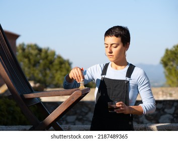 Young Woman Painting Cladding Wooden Chair In Outdoor, DIY Home Improvement.