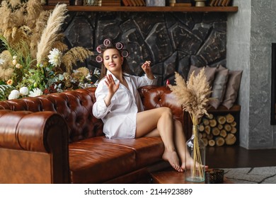 Young Woman Painting Fingernails With Red Enamel While Lying On Sofa, Doing Manicure At Home, Perfect Healthy Nails Care