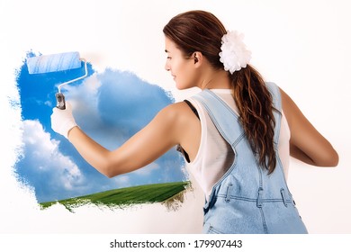 Young Woman Painting A Nature Landscape On Wall With Roller. Mural Painting On Wall. Ecologist