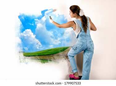 Young Woman Painting A Nature Landscape On Wall With Roller. Mural Painting On Wall. Ecologist