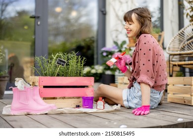 Young Woman Painting Wooden Box In Pink Color, Doing Some Renovating Housework On The Terrace Outdoors. DIY Concept